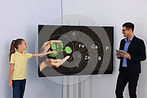 Teacher and pupil using interactive board in classroom during lesson