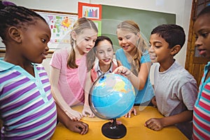 Teacher and pupils looking at globe