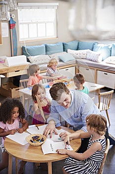 Teacher And Pupils Practicing Writing In Montessori School