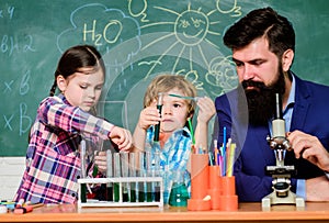 Teacher and pupils test tubes in classroom. Kids can grow in area of club such as science. Discover and explore