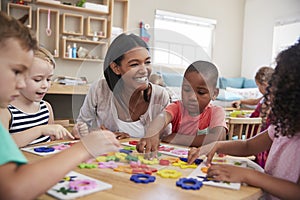 Teacher And Pupils Using Flower Shapes In Montessori School