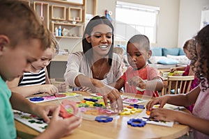 Teacher And Pupils Using Flower Shapes In Montessori School