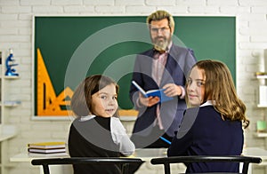 Teacher and pupils working at desk together at the elementary school. disclose and develop creativity. Teacher working