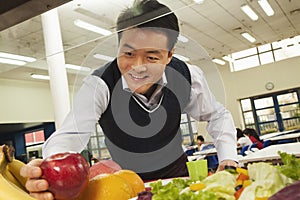 Teacher reaching for healthy food in school cafeteria