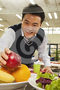 Teacher reaching for healthy food in school cafeteria