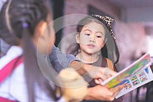 Teacher reading story book to kindergarten students Kid