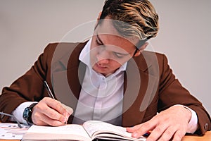 A teacher reviewing papers in the classroom. Business man dressed in cafe suit signing important papers. Man working in his office