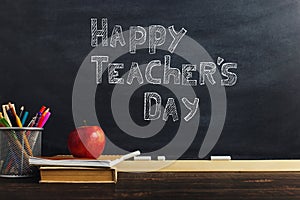 Teacher's desk with writing materials, a book and an apple, a blank for text or a background for a school theme. Copy space