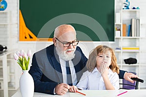 Teacher and school boy doing homework assignment at school.