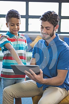 Teacher and school kid using digital table in library