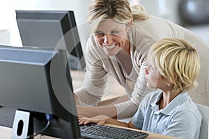 Teacher with schoolboy on computer