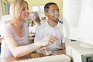 Teacher and schoolboy studying on a computer