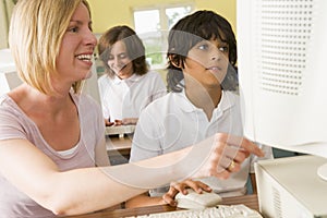 Teacher and schoolboy studying on a computer
