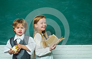 Teacher schoolgirl helping schoolboy with lesson. Elementary school kids in classroom at school. Education first