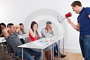 Teacher Shouting Through Megaphone On University Students