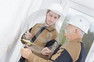 Teacher showing apprentice how to float cement