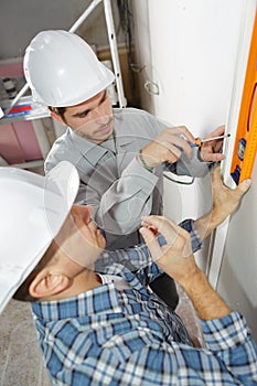 Teacher showing apprentice how to float cement