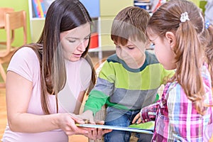 Teacher Showing a Book to Children at the Nurcery