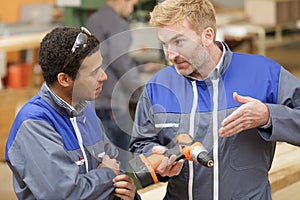 teacher showing drill to carpentry student