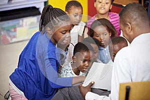 Teacher showing kids a book during elementary school lesson