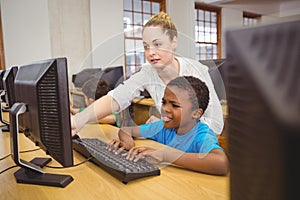 Teacher showing students how to use a computer