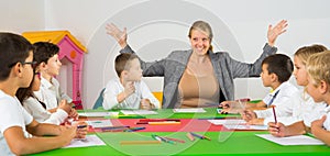 Teacher sitting around desk with children