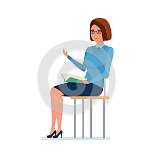 Teacher sitting on chair, holding book and explains school material.