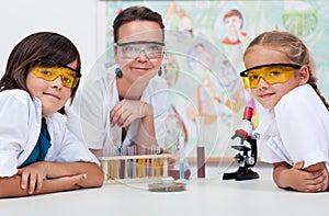 Teacher sitting at the desk with her young students