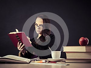 Teacher sitting at her desk reading