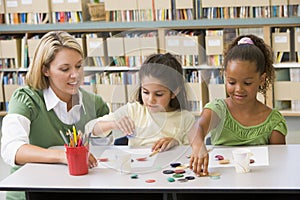 Teacher sitting with students in art class