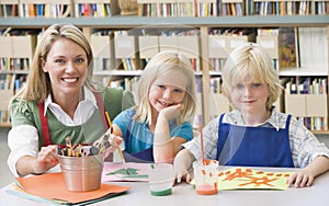 Teacher sitting with students in art class