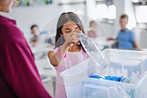 A teacher with small school kids in classroom learning about waste separation.