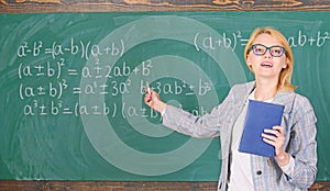 Teacher smart woman with book explain topic near chalkboard. School teacher explain things well and make subject