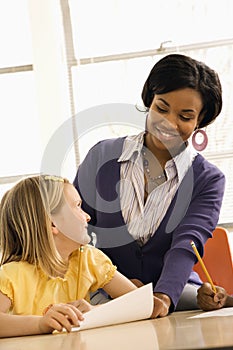 Teacher Smiling and Helping Student