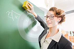 Teacher with a sponge in front of a school class