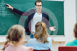 Teacher standing in front of students in school class