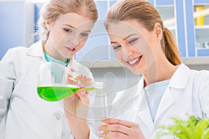 Teacher and student chemists making experiment in laboratory