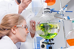 Teacher and student scientists in white coats making experiment