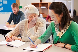 Teacher and student sit together at an adult education class