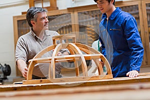 Teacher and student talking about a wooden frame