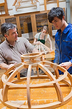 Teacher and a student in a woodworking class working on a frame