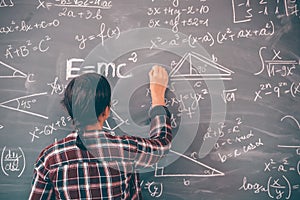 Teacher or student writing on blackboard during math lesson in school classroom