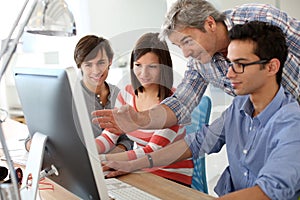 Teacher with students in classroom using computer