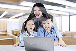 Teacher and students looking at laptop