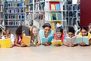 Teacher with students reading books while lying down