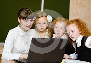 Teacher and students use computers in the classroom