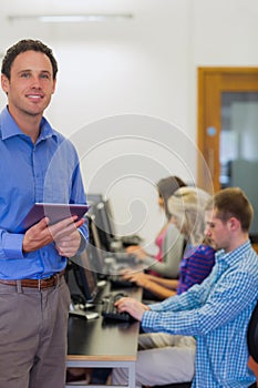 Teacher with students using computers in computer room