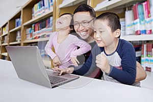 Teacher with students using a laptop