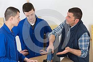 Teacher and students at workbench in woodworking class