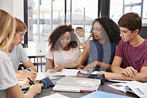 Teacher studying school books in class with high school kids